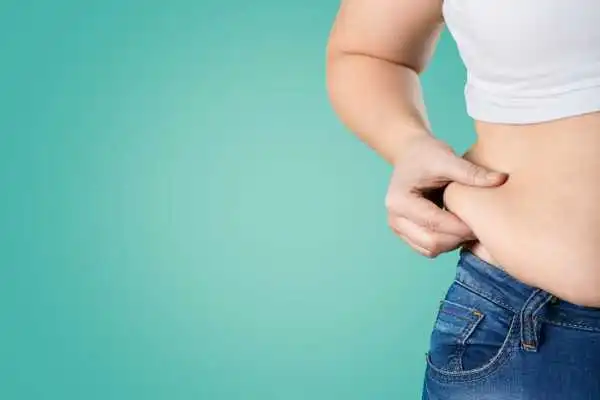 Image of woman pinching her love handles to show weight gain Kensington and Chelsea