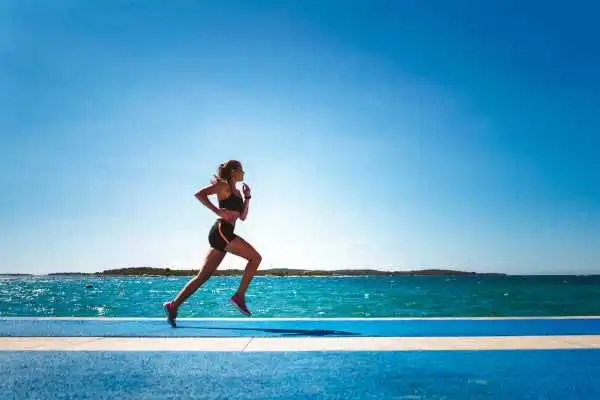 Woman running showing strong leg muscle Kensington and Chelsea
